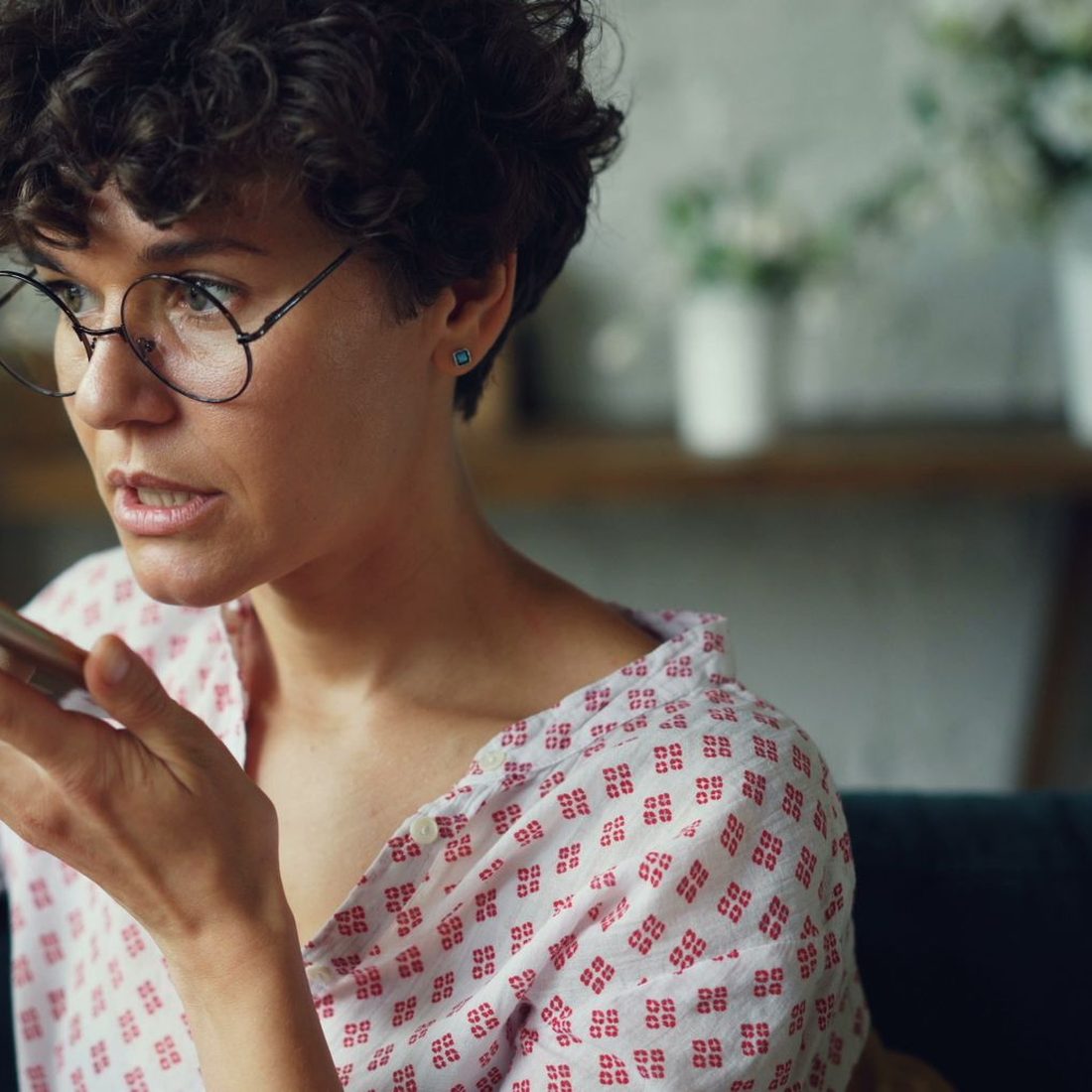 A woman speaking a question into her phone, the moment an assistant answers with two or three brand names